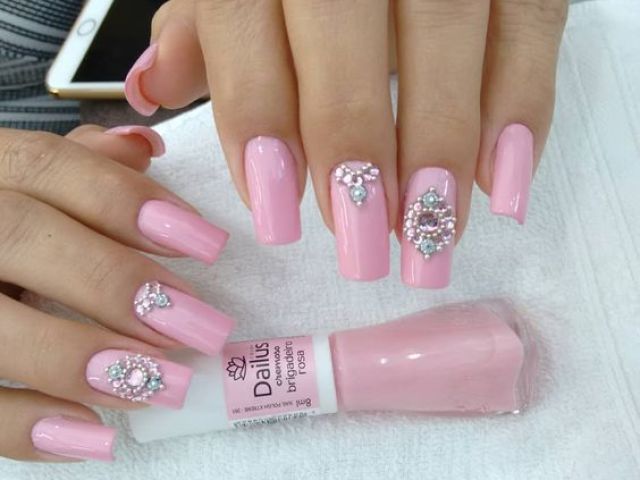 Unhas rosa claro.