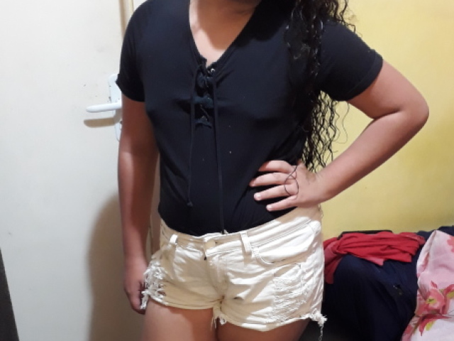 Com um short jeans branco e uma blusa preta