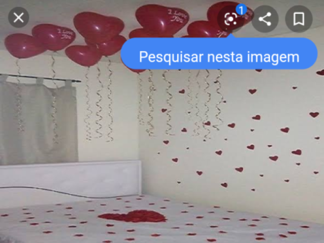 bem simples decorativo com coração na cama e cartinhas em uma caixinha e balões em formatos de coração no teto