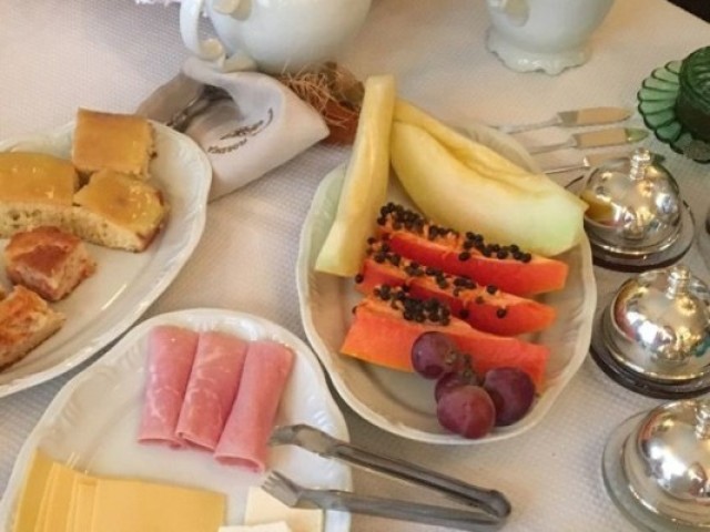 Sentar na mesa e comer um café da manhã completo com seus pais