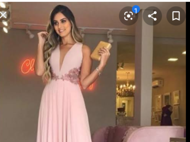 Um vestido rosa longo com e uma bolsa pequena bem fashion