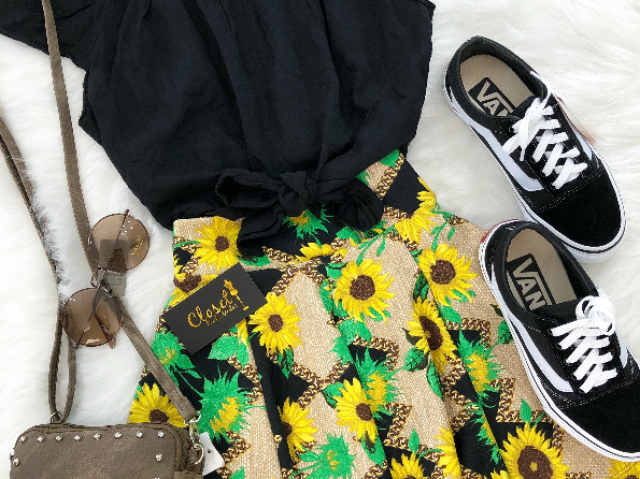 Uma blusa preta , uma saia de girassol,um tênis vans,um óculos de sol,uma bolsa marrom!