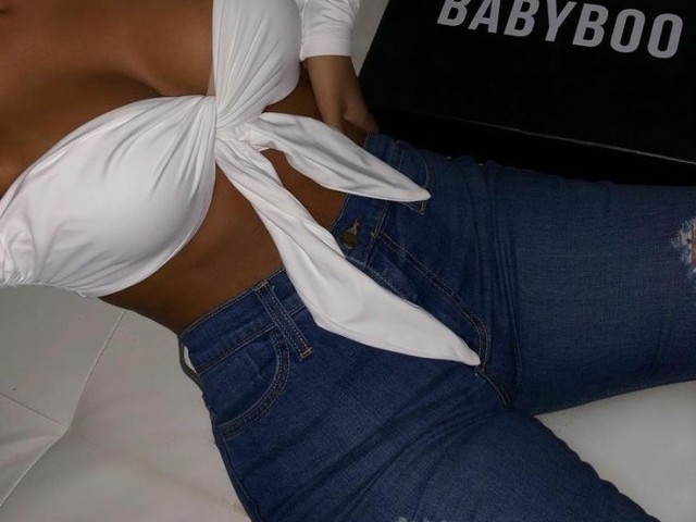 Calça jeans rasgada na coxa e um cropped aberto na frente de manga longa