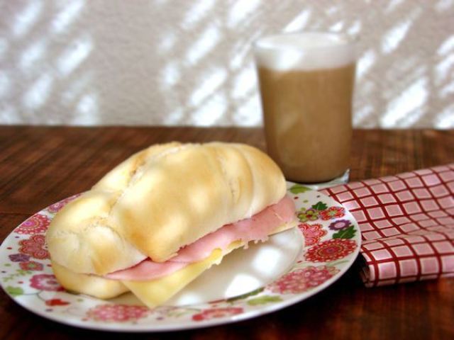 Pão com presunto e queijo e um café