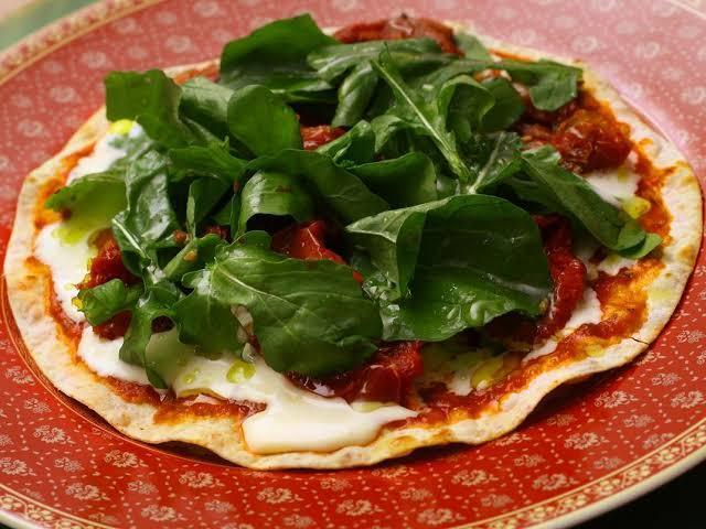 Pizza de rúcula com tomate seco