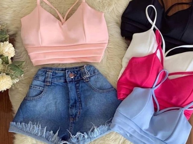 Top pink, shorts jeans , tênis adidas.