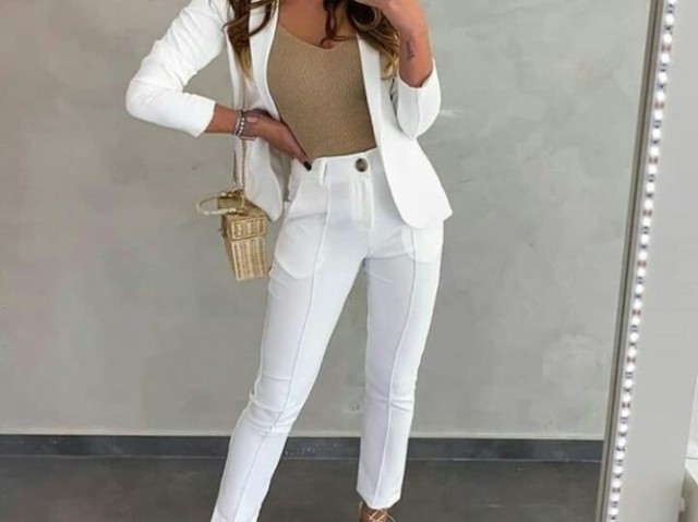 Uma blusa nude, um Blazer e calça brancos, uma bolsa dourada, um relógio de ouro.