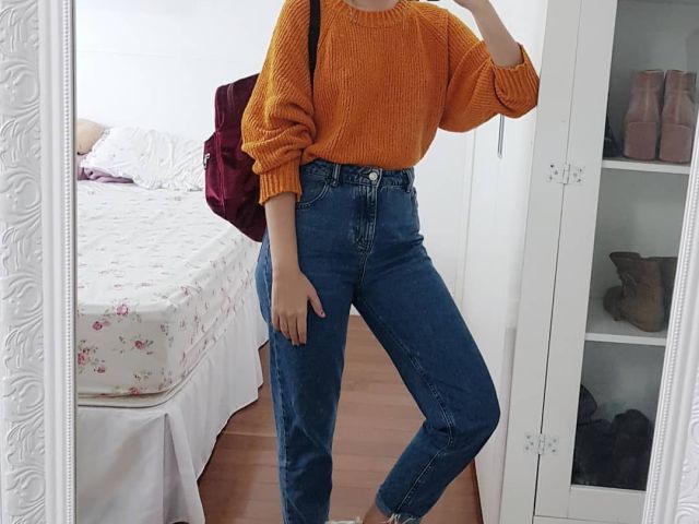 Um sweter com calça jeans.