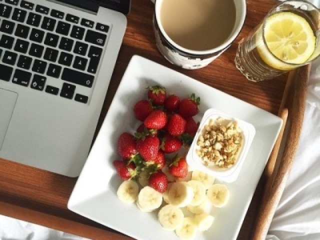 Café com leite, morangos, banana e iogurte com granola