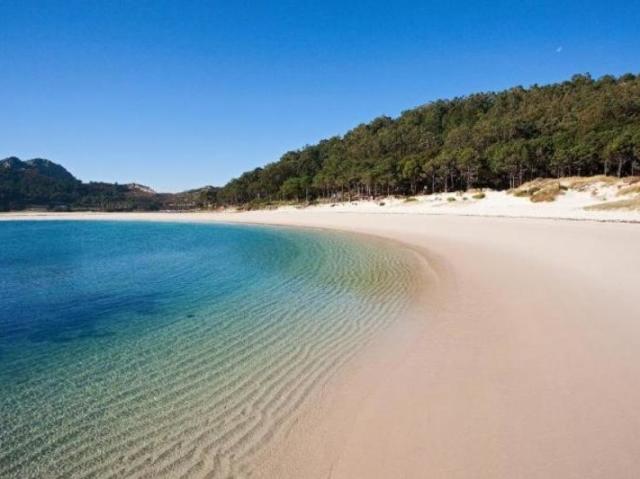 Uma bela praia de areia branca e água límpida quente.