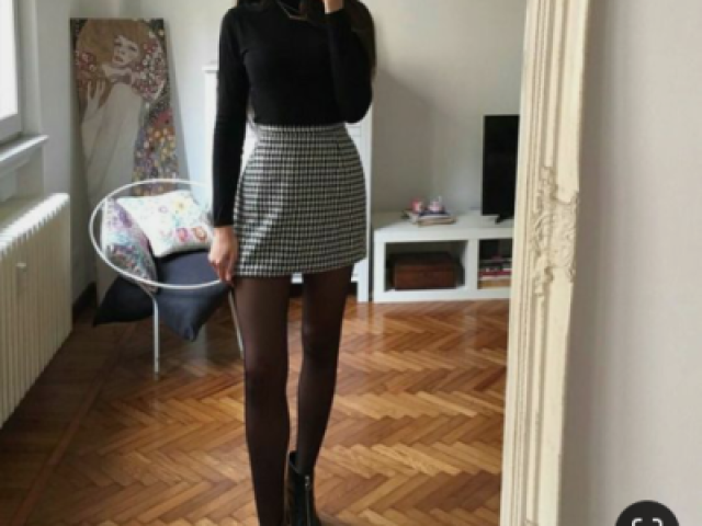 đ»Blusa longa preta,com uma saia xadrez e uma meia calçađ»