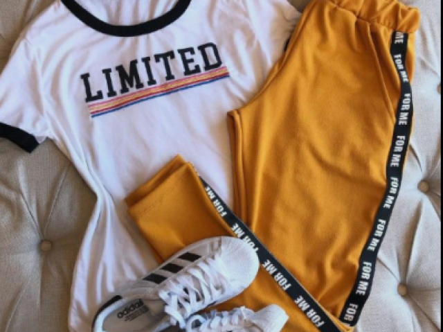 >T-shirt branca com uma calça de moletom amarelo, e um tênis branco da Adidas