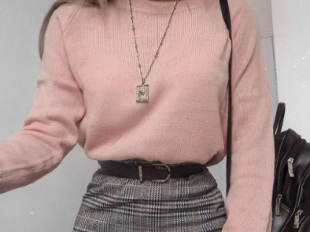 >Uma blusa de tricô rosa,com uma saia cinza bem curta com um coturno preto