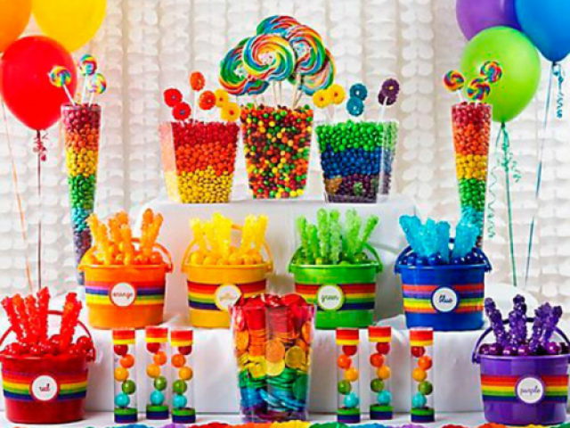 Uma mesa toda colorida e cheio de doces