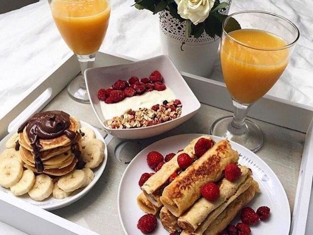 panquecas com bananas e nutella, iogurte com cereal e framboesa, suco de laranja.