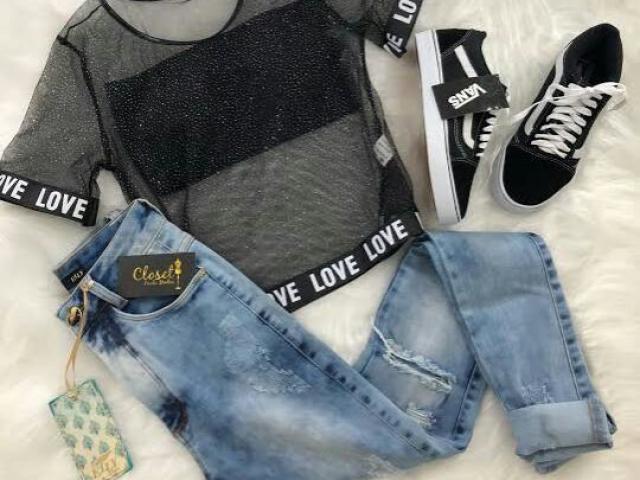 Calça jeans, cropped faixa preto, blusa transparente e tênis preto.