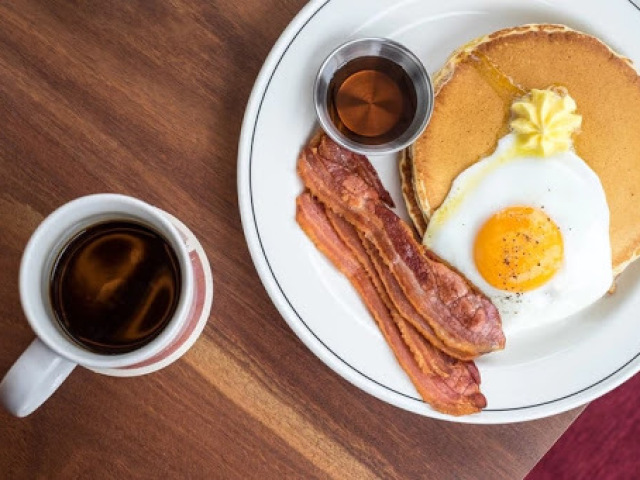 esse bem americano, que tem panqueca, bacon, ovo frito e mel para a panqueca.