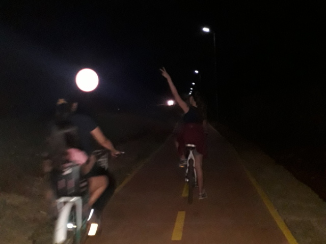 Ou andar de bicicleta de noite com um criança na cadeirinha