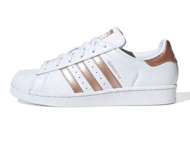 Um adidas superstar com listras bronze