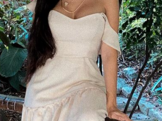 Esse é um vestido longo branco com manga caída .