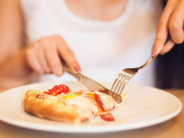 Comer pizza com garfo e faca