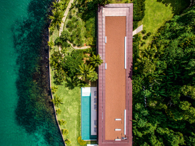 Uma vista que a casa seja rodada de árvores e mar.