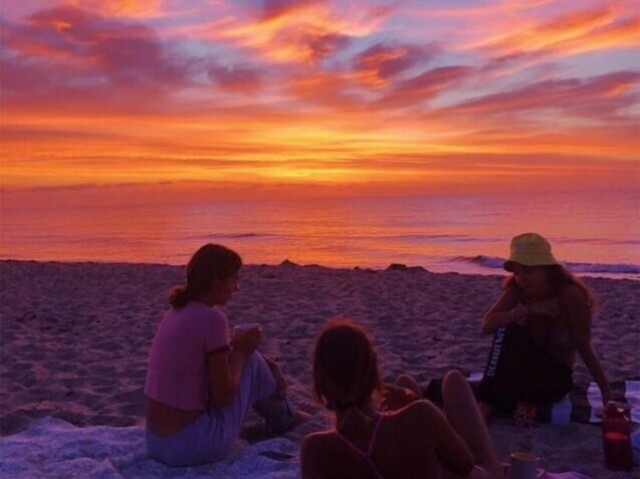 Com amigos na praia observando o por do sol.