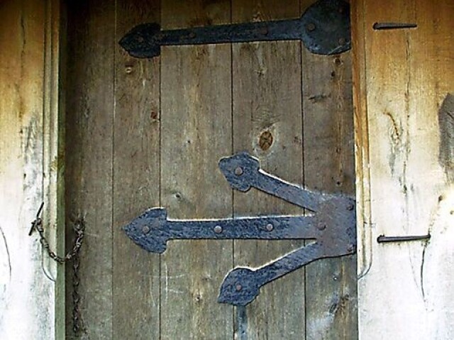 Uma porta de madeira e ferro comum, que se encontra em qualquer taverna.