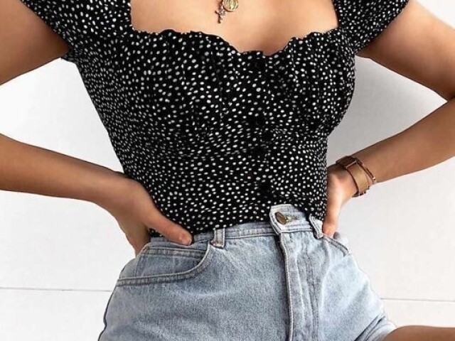 Blusa preta com bolinhas e um short.