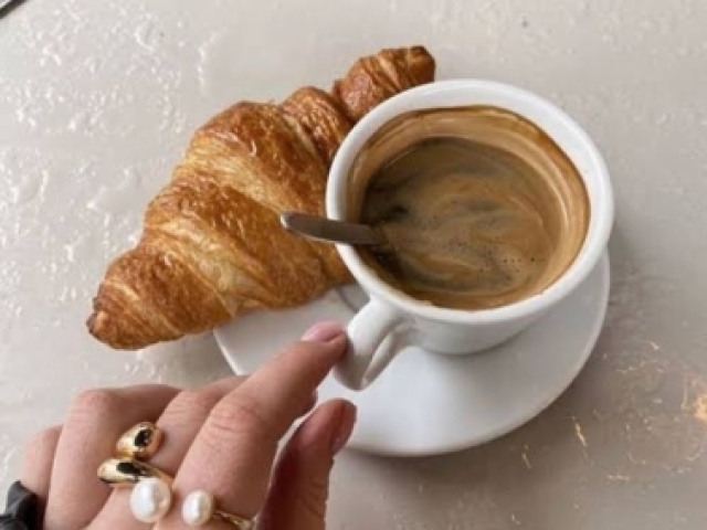 Café preto com um croissant