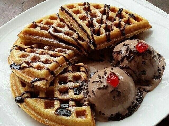 Waffles com sorvete, chocolate, cereja e granulado.