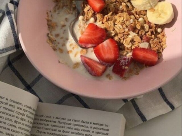 Cereal com frutas e cafézinho, junto, lendo um livro.