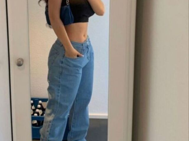 Estilo swag, bem despojada, com uma calça jeans larga e um cropped básico com uma bolsinha básica, bem simples, porém chama atenção