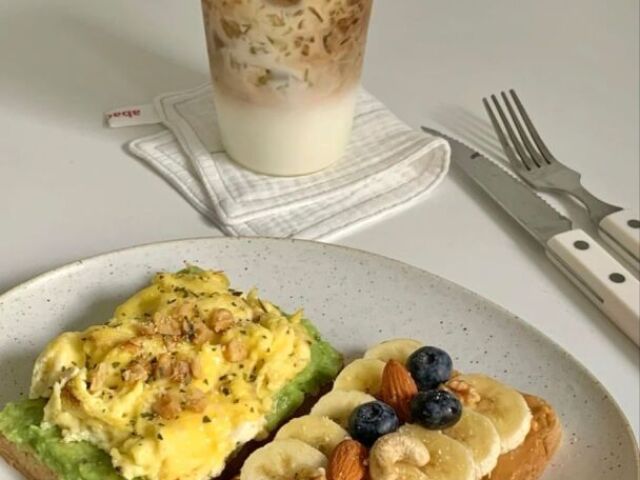 torrada com guacamole e ovo e outra torrada com pasta de amendoim banana blueberry e casatanha e pra beber café gelado com chantilli