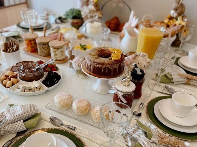 Bolo de damasco, pães, geleia, suco de laranja e café.