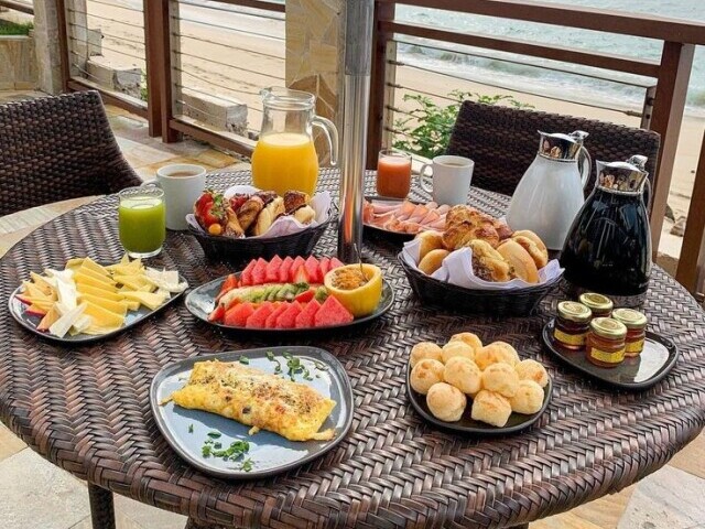 Suco de laranja, café frutas diversas, pães de queijo, omelete, pães franceses e queijo.