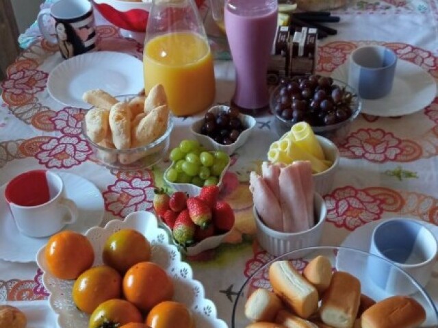 Suco de laranja, iogurte, presunto e queijo, frutas e pães.