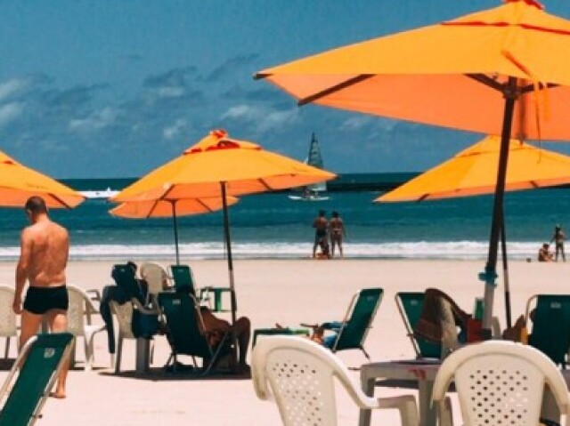 Na praia, onde faz bastante sol e calor.