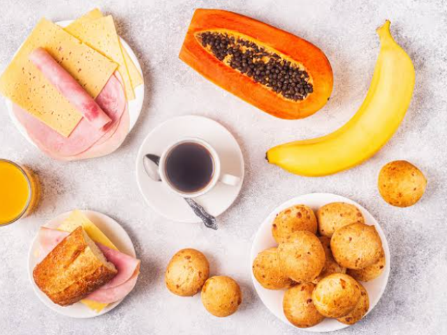 Café , pão de queijo , mussarela , presunto , suco de laranja , mamão , banana e pão .