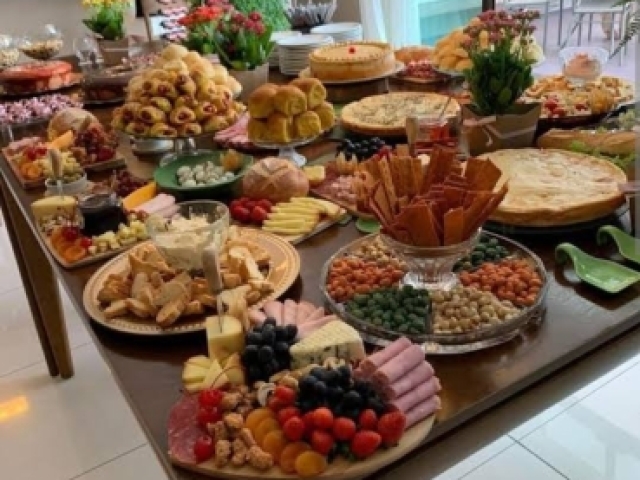 Uma mesa cheia de comida esperando por vocĂȘ.