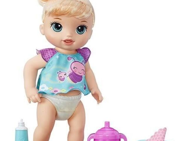 Uma baby alive com 3 itens, um creme dental, um copinho de suquinho e um lenço umedecido.