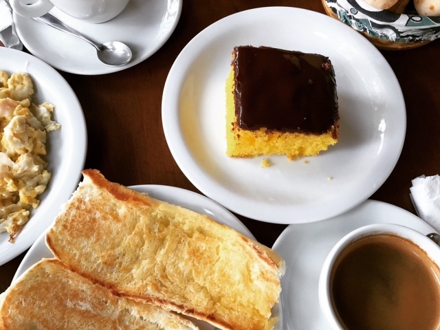 Bolo, chocolate quente, pão com manteiga