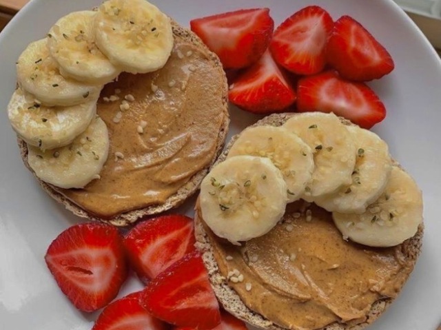 Algumas panquecas com pasta de amedoim, banana e morangos