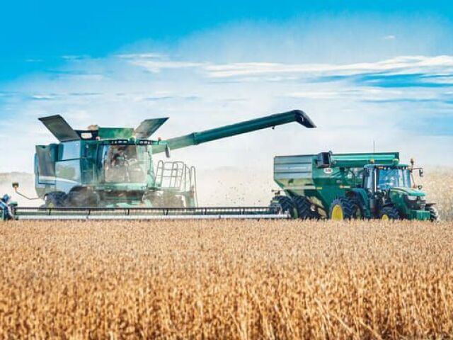 Fazenda produtiva com agricultores trabalhando em máquinas agrícolas.